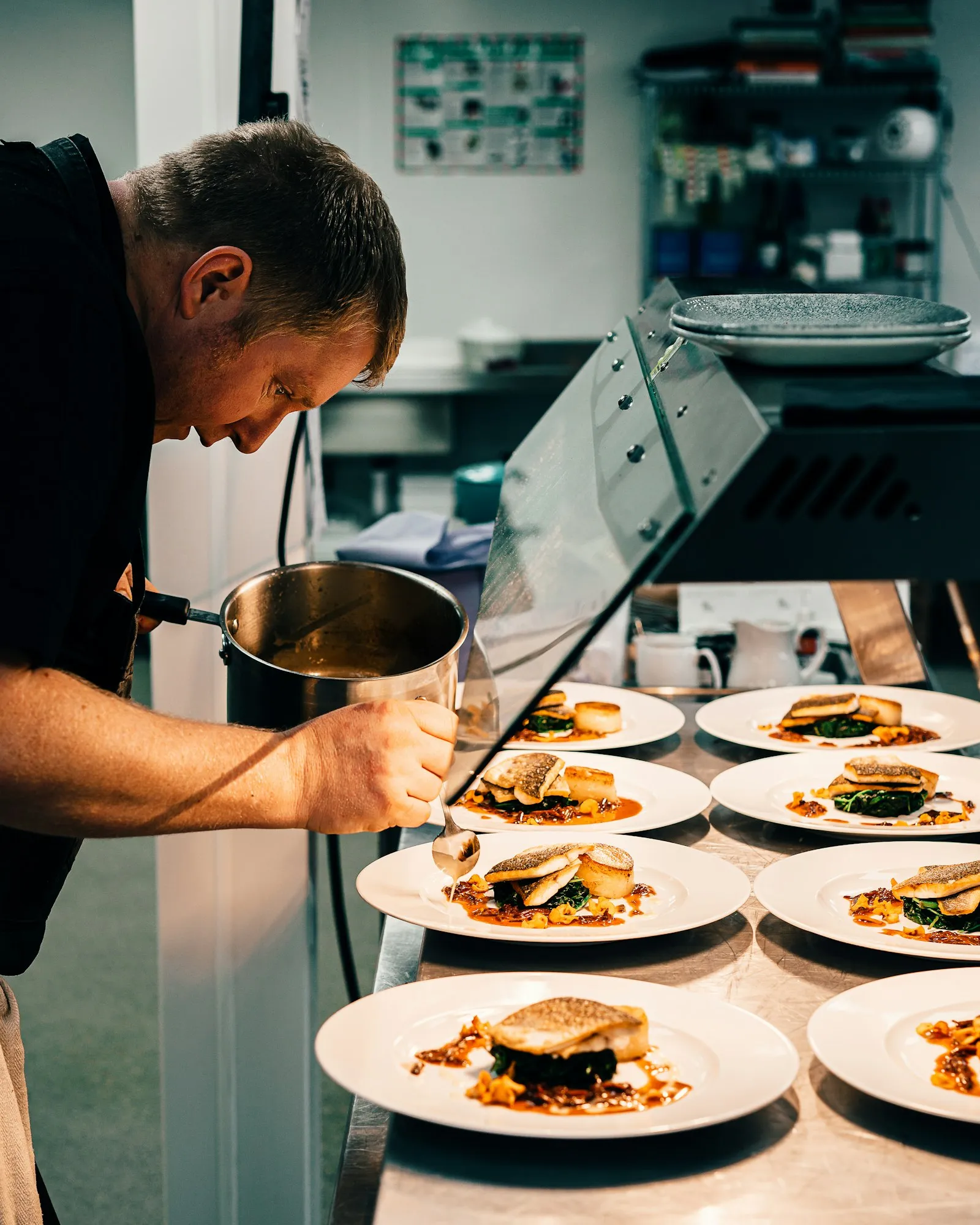 Küchenchef nimmt sich am Pass Zeit für ein Einarbeitungsgespräch mit einem neuen Koch